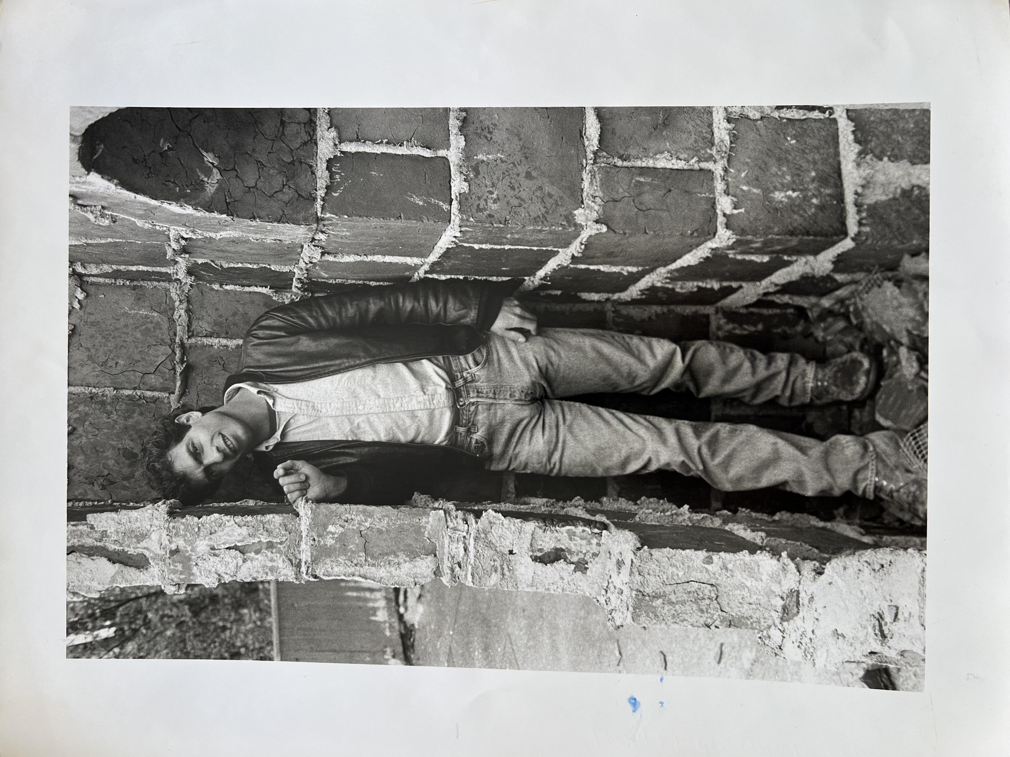 Young Buddy leaning against a brick wall